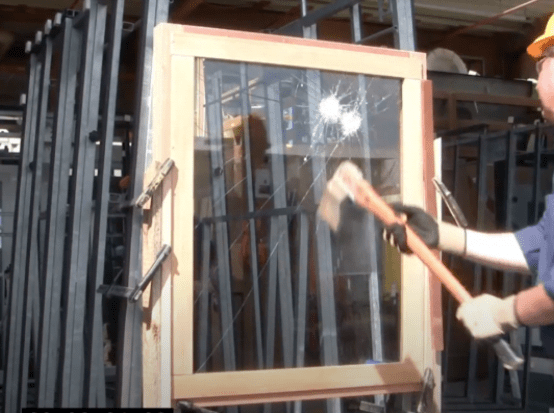 The process of testing the strength of glass used in windows and doors involves striking the glass with a heavy hammer to evaluate its durability and impact resistance.