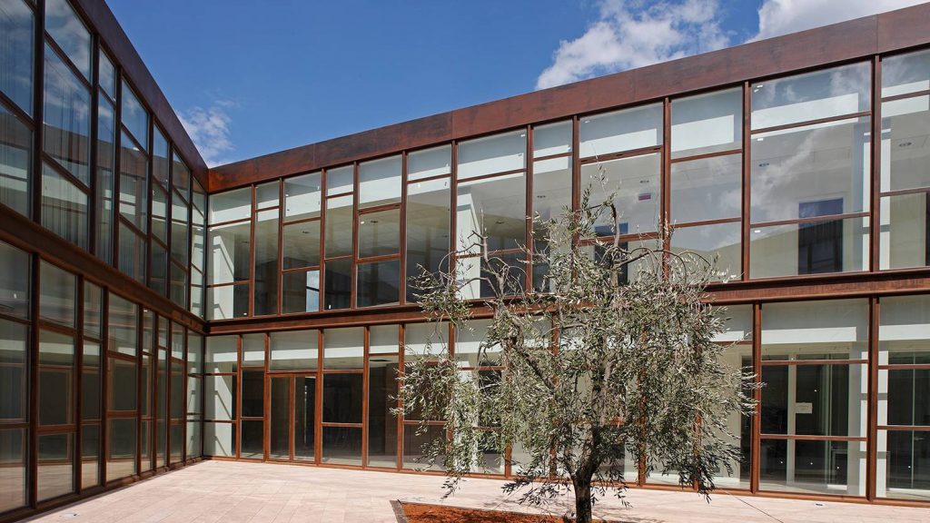 The two-story interior facade of the commercial building is executed using Corten Steel Windows and Doors.