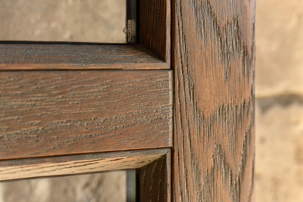 Close-up showcases the rich texture of a wooden frame, emphasizing the natural grain and intricate detailing of the material, highlighting the depth and organic beauty of the wood, providing an elegant, rustic aesthetic, captures the fine craftsmanship and the interplay of light on the surface, which enhances its visual appeal.